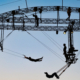 A silhouette of flying trapeze artists and a framework construction